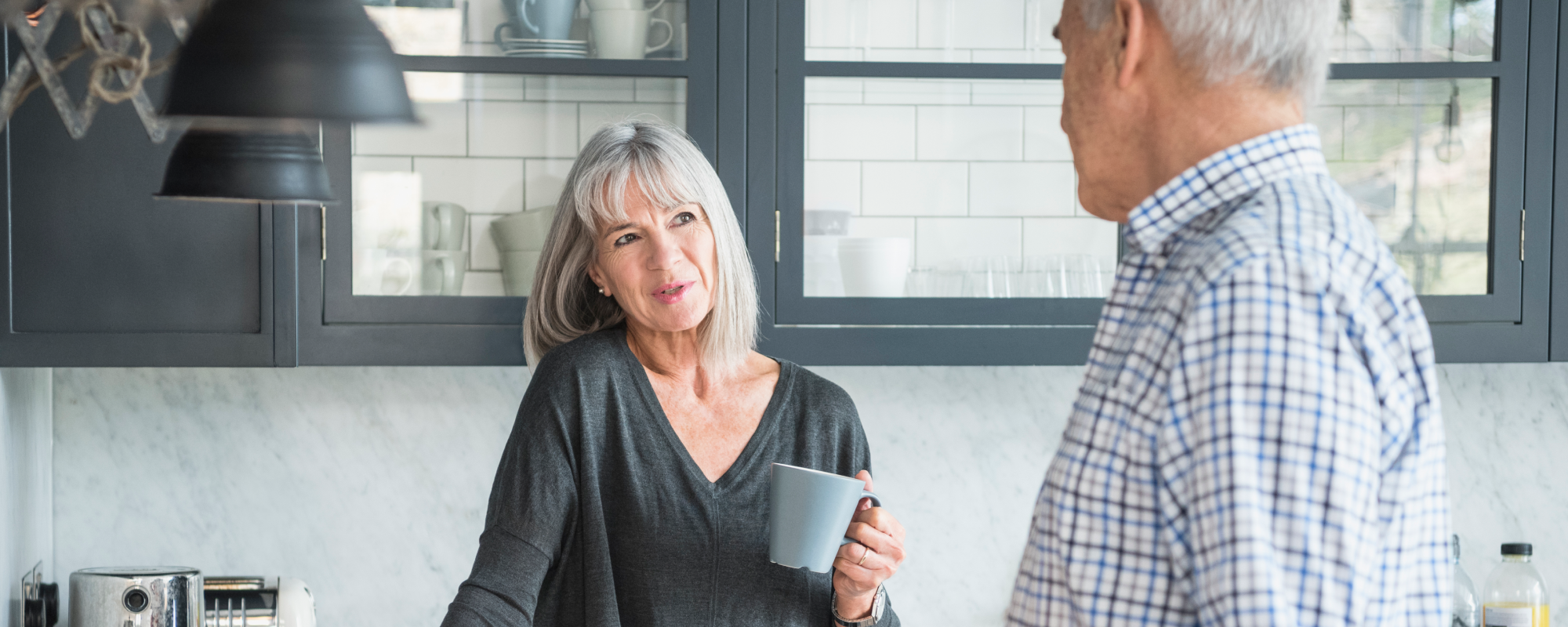 Un homme et une femme avec une tasse de café dans la cuisine discutent