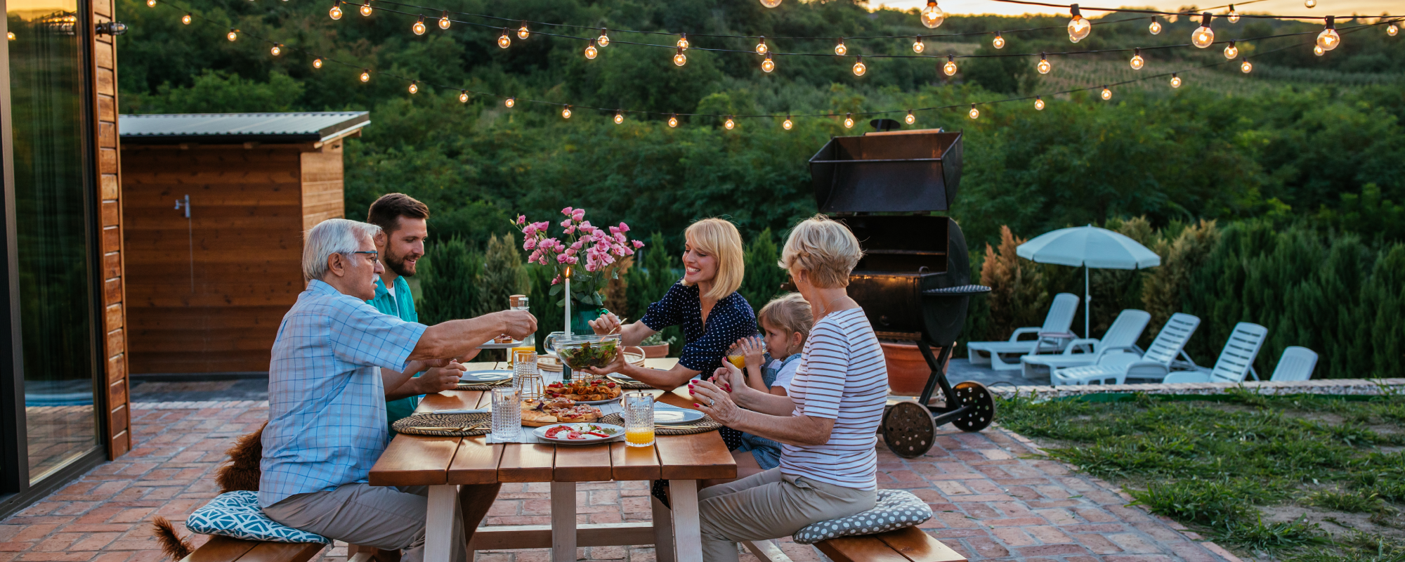 Family eating dinner in the backyard after a BBQ