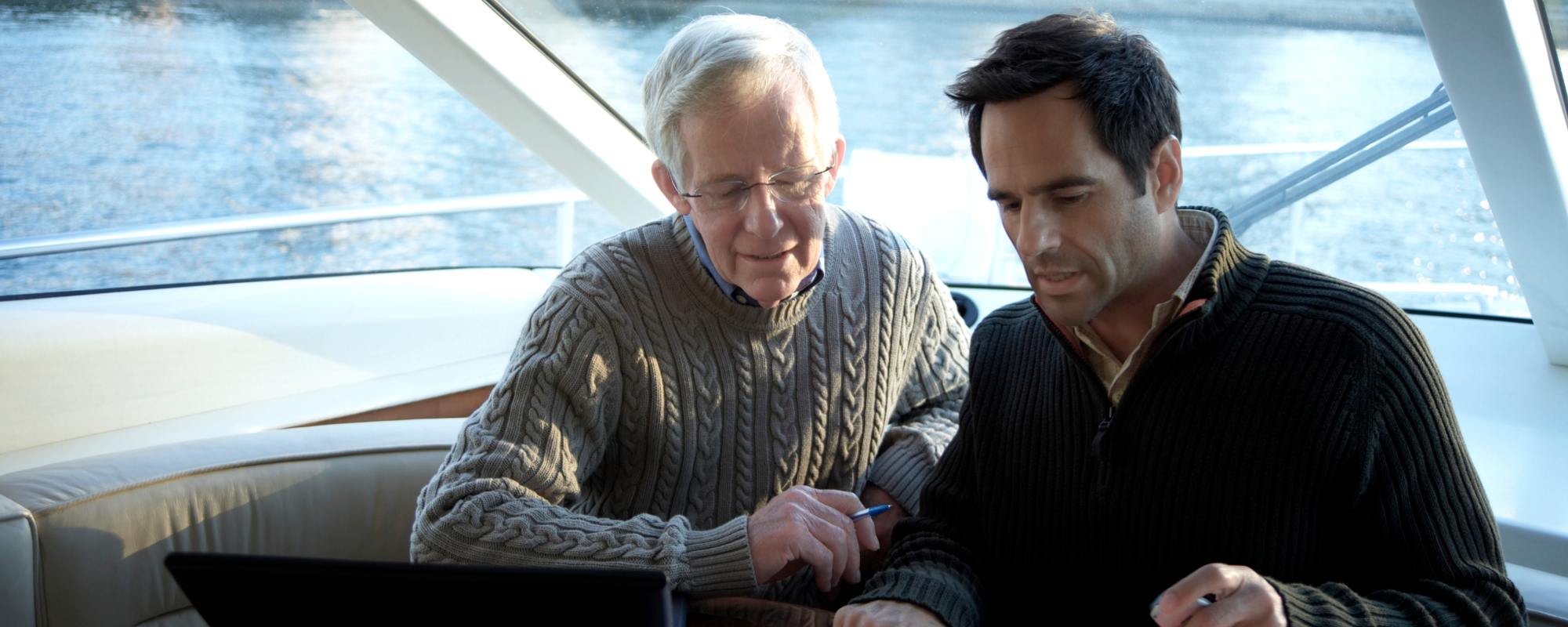 Man and his father on a boat reviewing documents