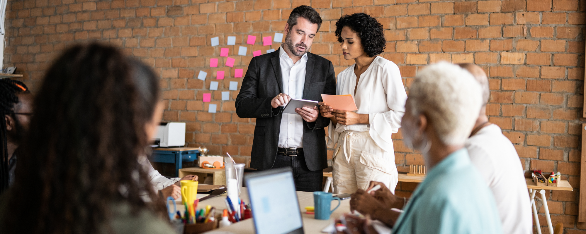 Man and a women looking over notes in a casual office environment