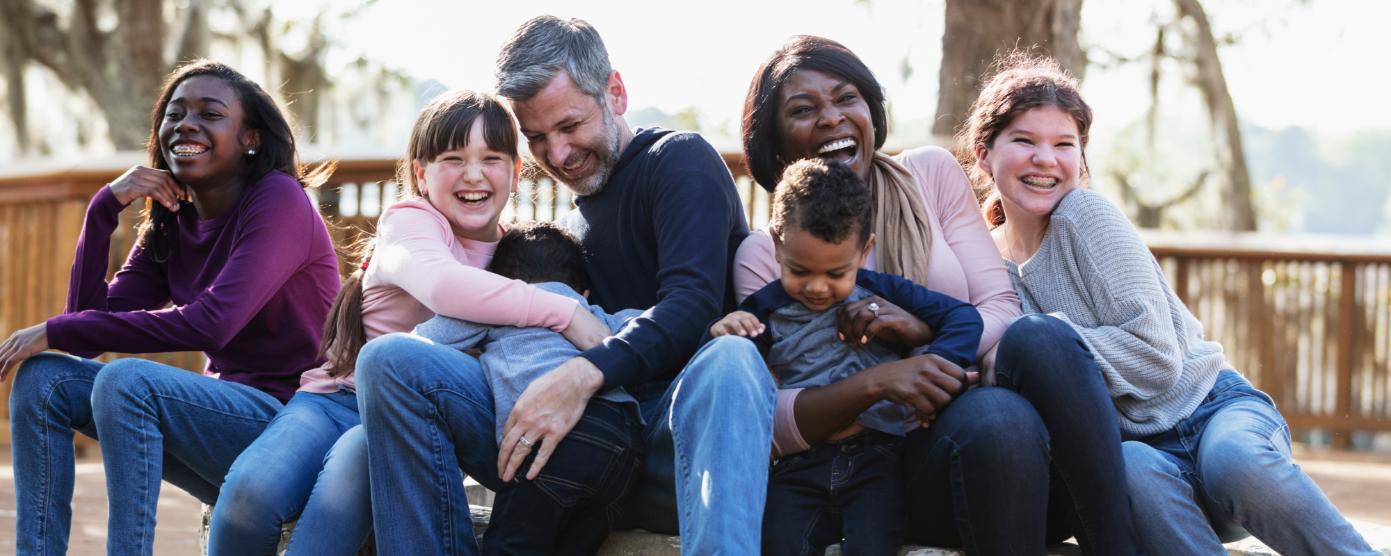 Family embracing each other on a park bench