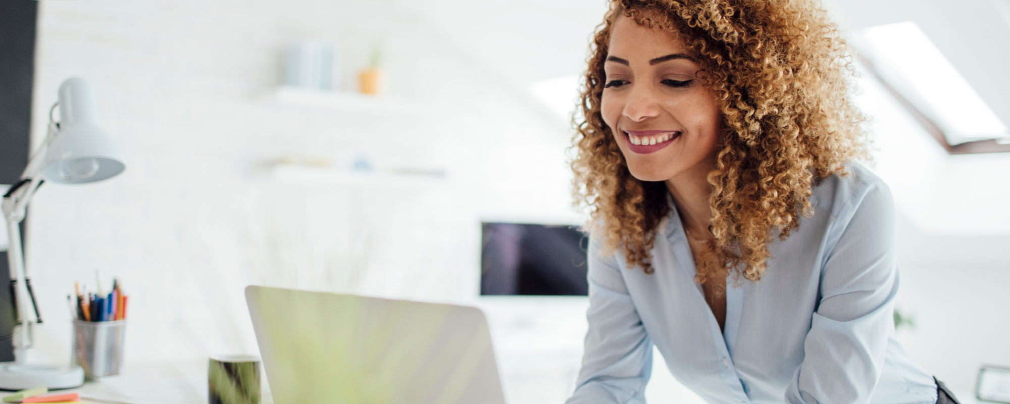 Femme sur ordinateur portable dans un espace de bureau lumineux