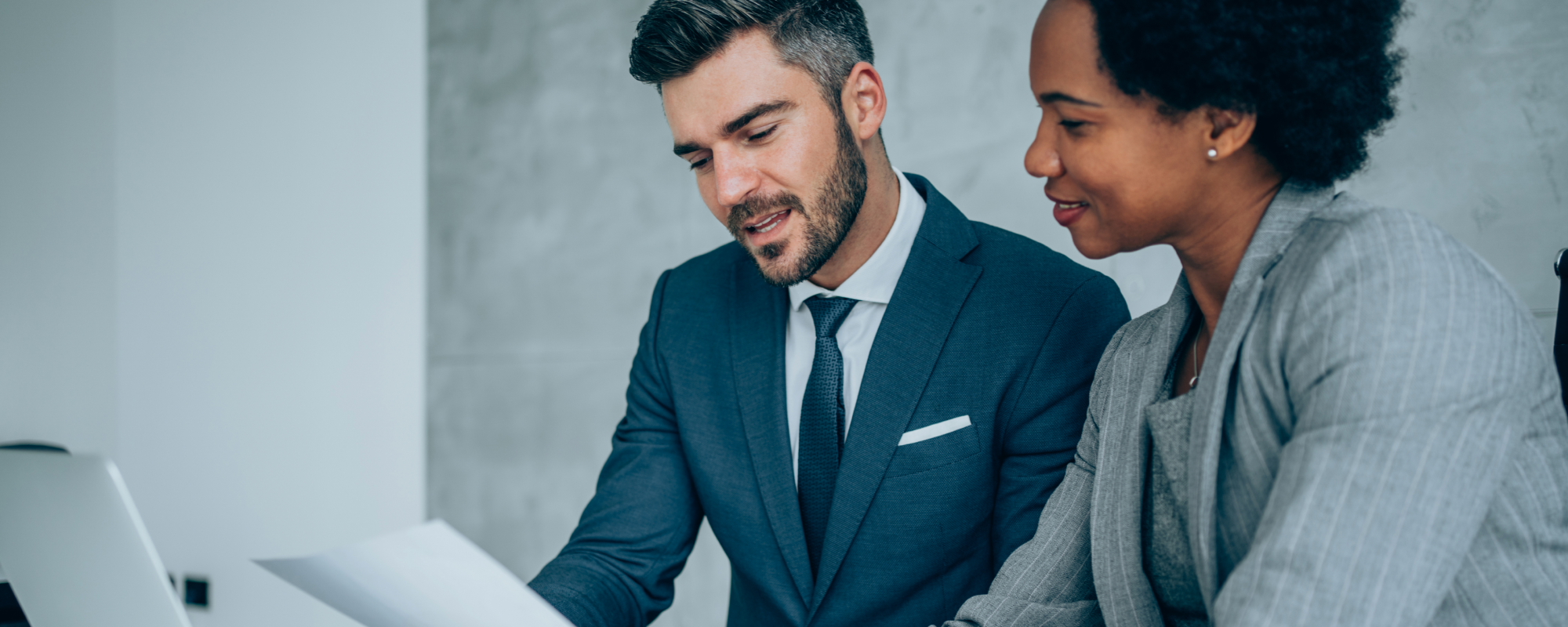 Man and a woman reviewing a laptop in the office