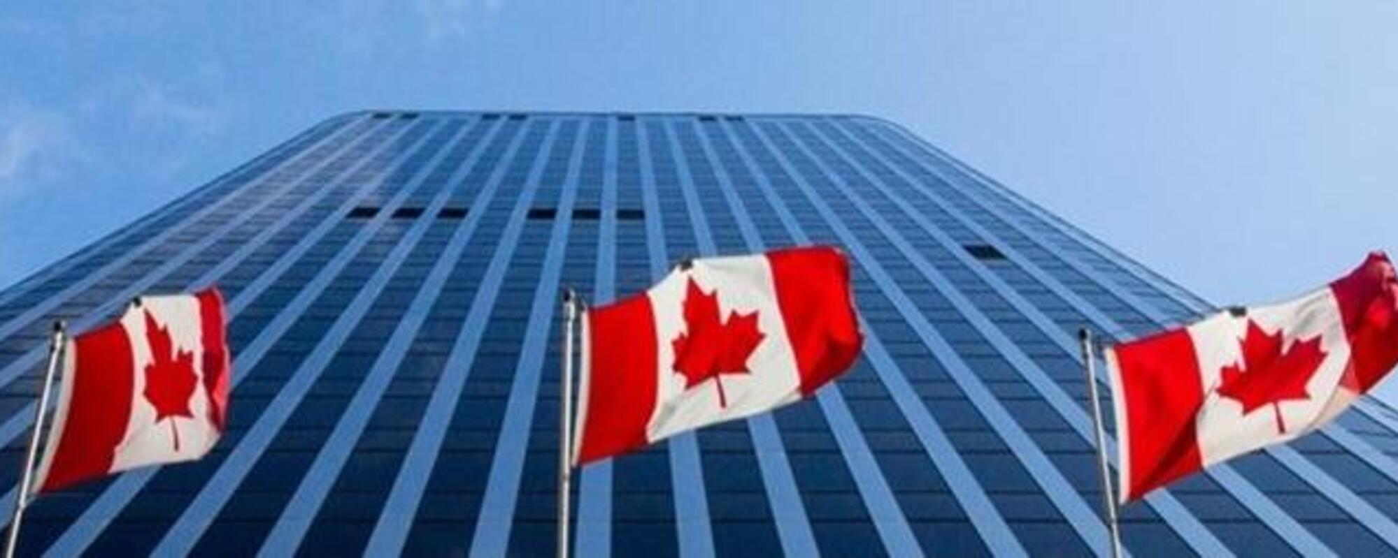 immeuble de bureaux avec des drapeaux canadiens.