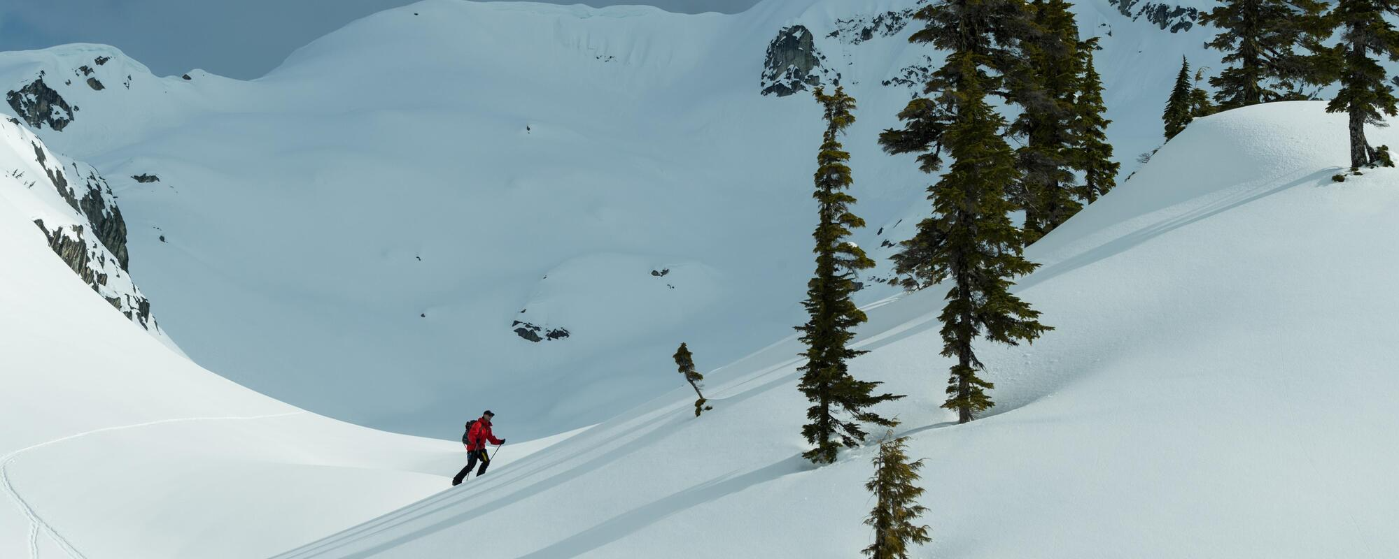 person climbing up snow covered hill.