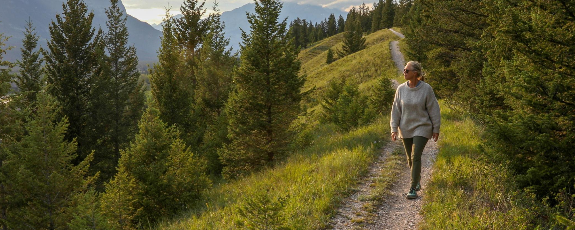 Une femme d'âge mûr descend un sentier le matin.