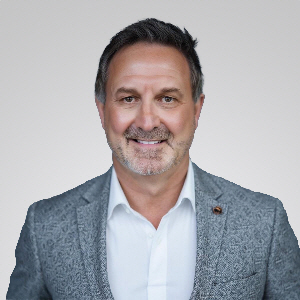 Headshot of Kelly Hauser in a White Shirt and Gray Blazer