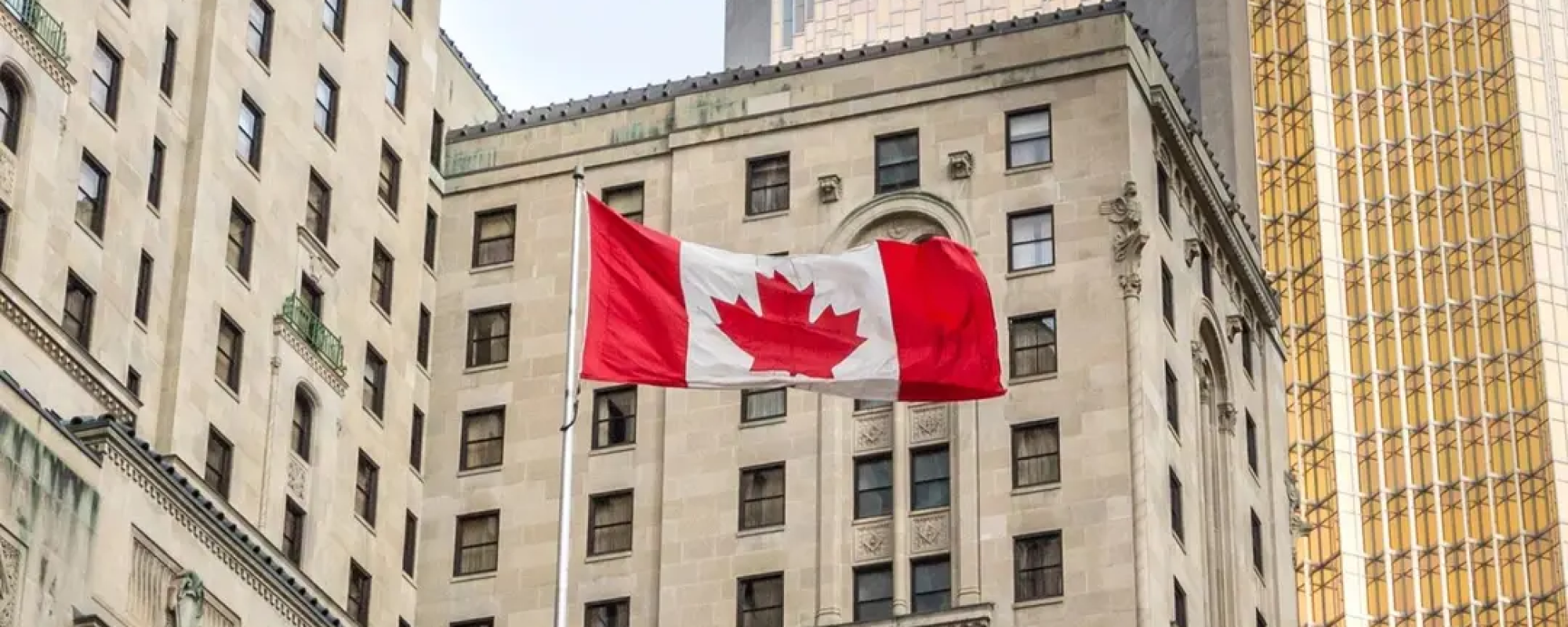 Canadian flag flying in front of business building in Toronto, Ontario