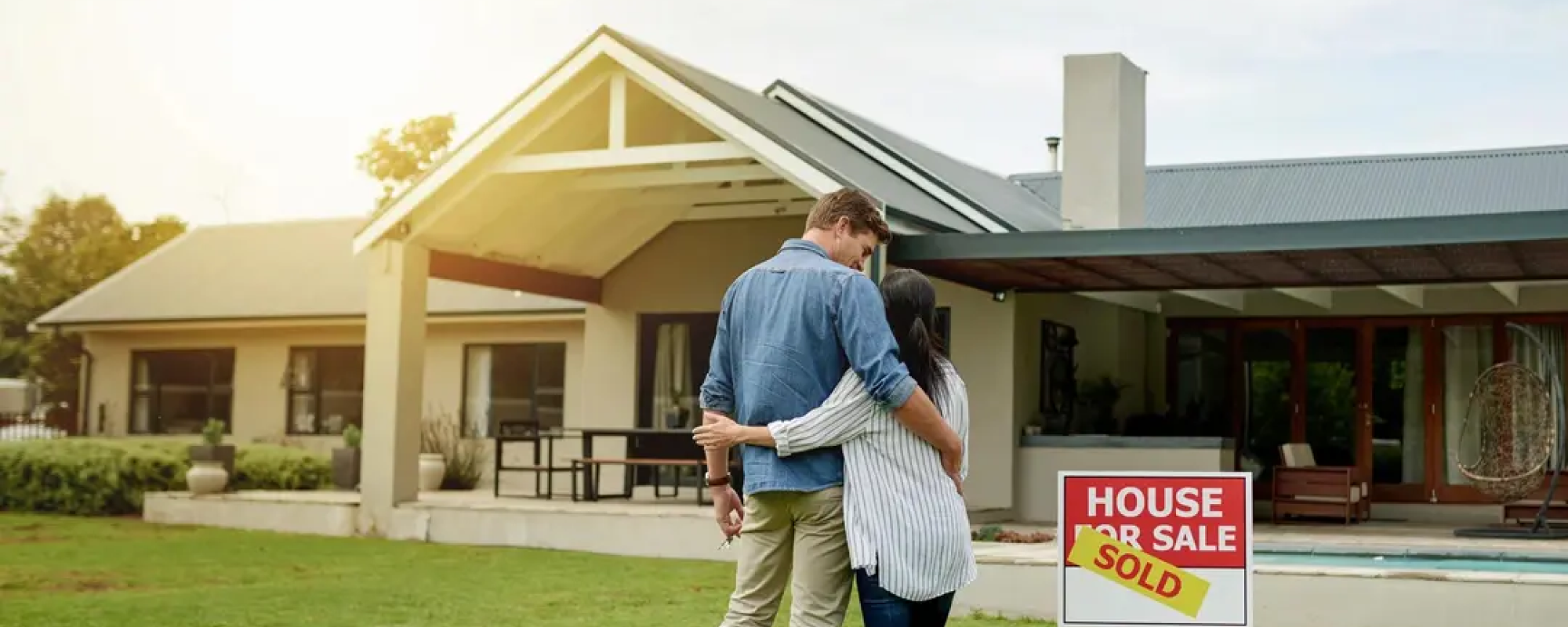 couple standing in front of a house