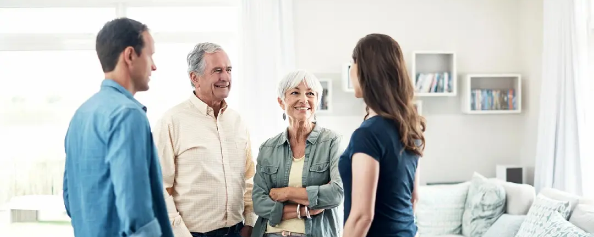 intergenerational family standing in home talking