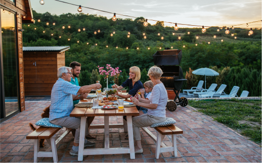 family of six enjoying a meal at a picnic table outside