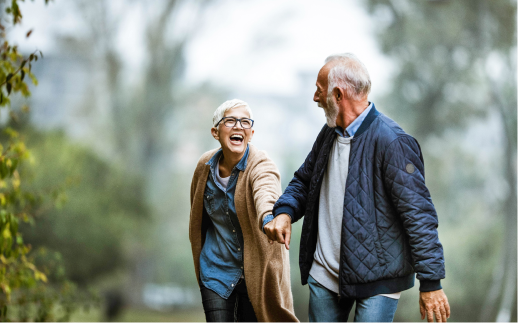 man and woman laughing while hiking in a forest