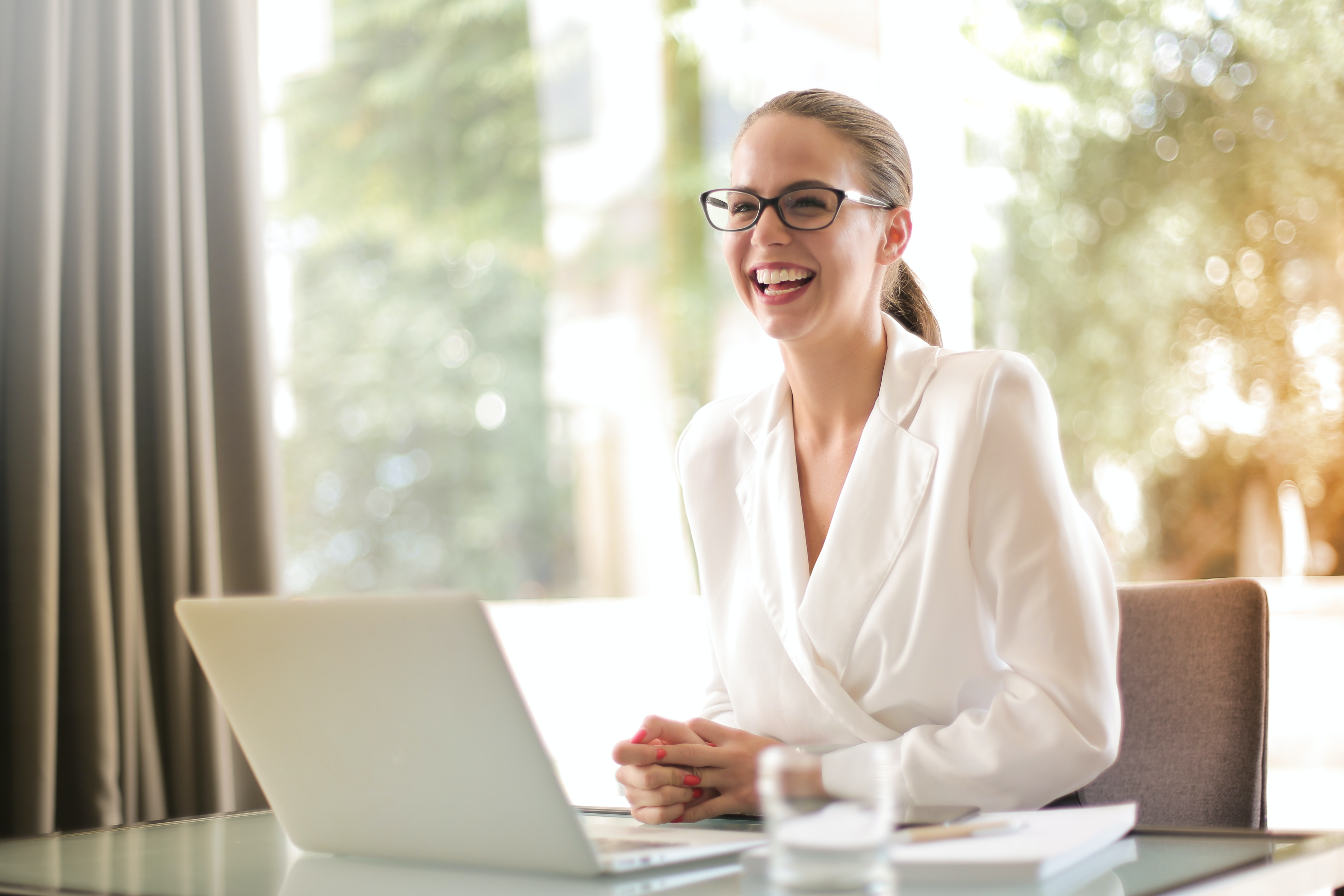 woman working on a laptop, smiling