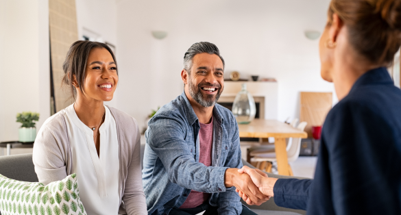 man and woman sitting on couch shaking hands with lady across from them