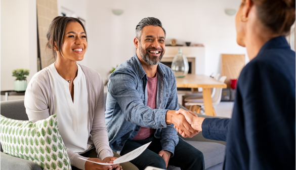 man and woman sitting on couch shaking hands with lady sitting across from them