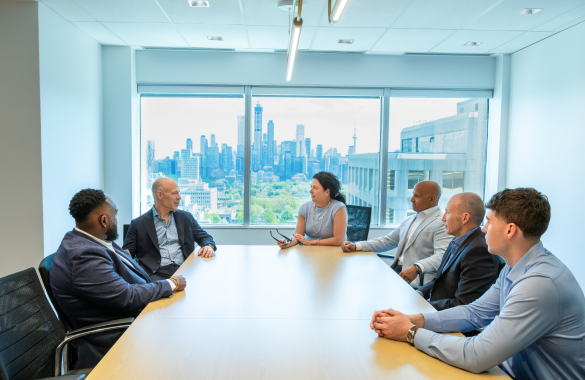 Six people sitting in a boardroom