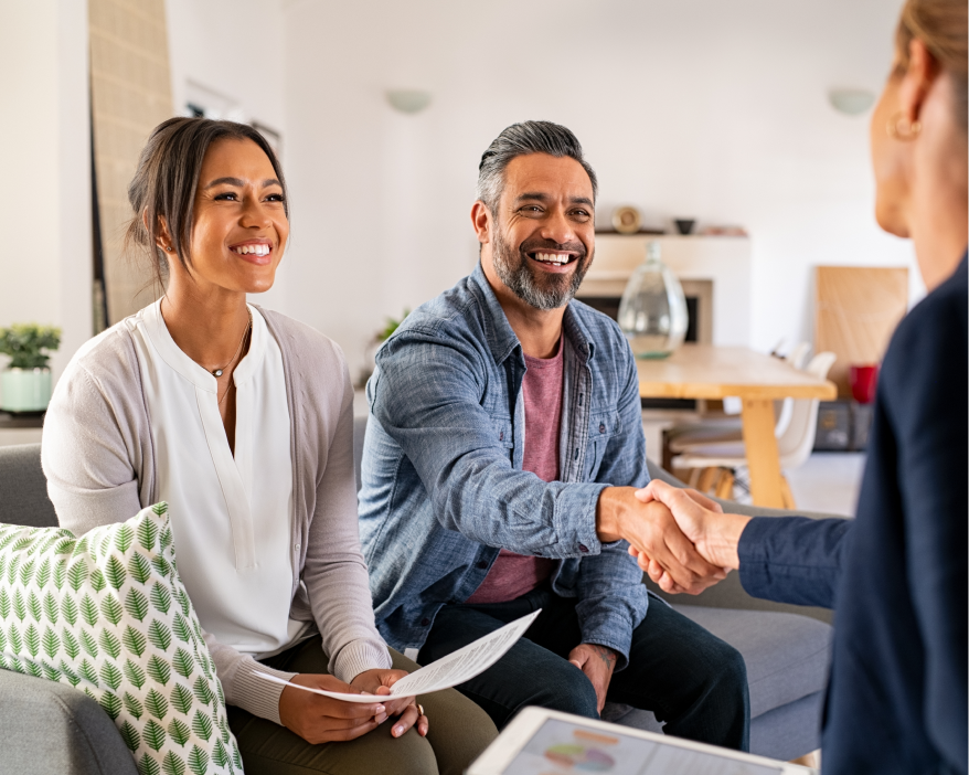 man and woman sitting on couch shaking hands with lady across from them