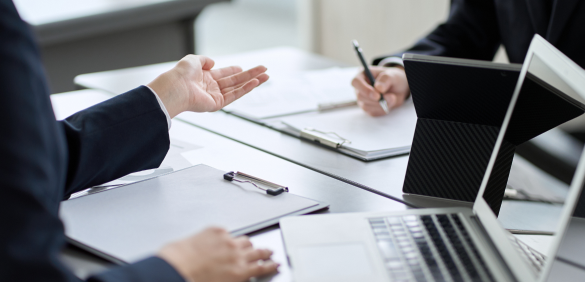 two people talking at a desk