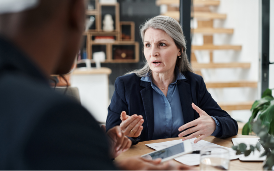 woman in suit speaking to person out of frame