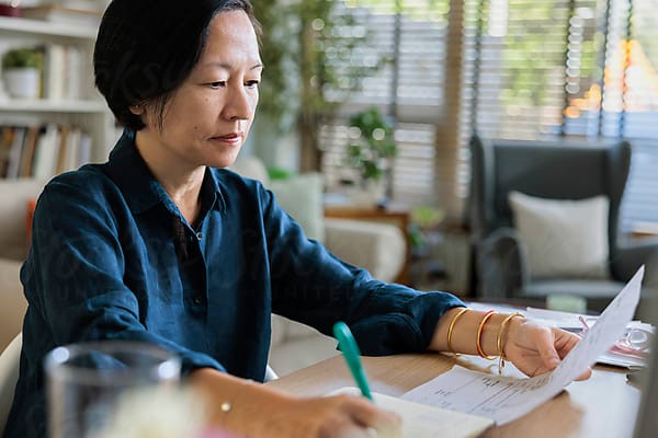 A person reviewing paperwork at home.