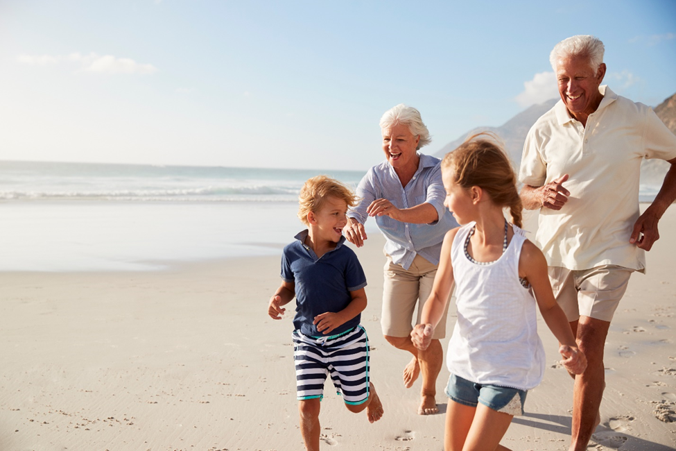 grandparents chasing their children on a beach