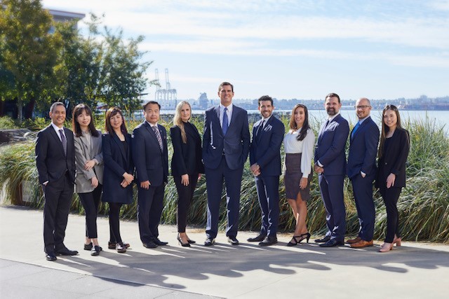 McLean Harland Wealth Management Group standing outside, in front of a city skyline