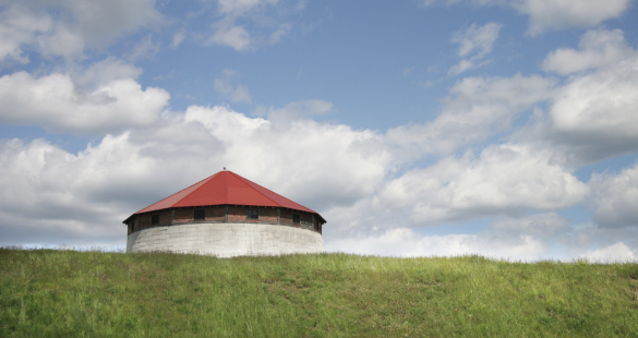 short red-roofed silo in a field