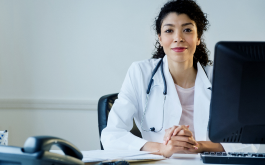 doctor sitting at table with computer
