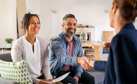 couple shaking hands with lady in a suit