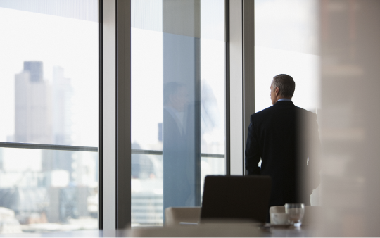 Man in suit standing by a window
