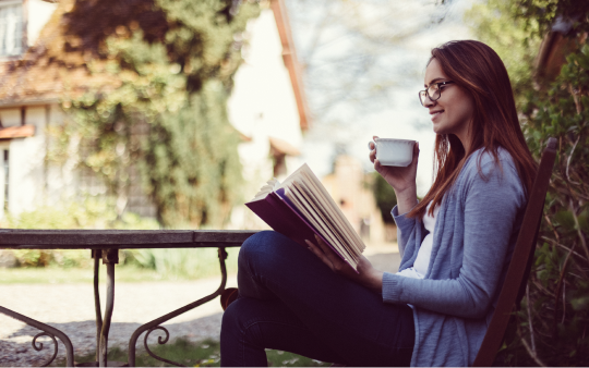 woman sitting under a tree reading a book