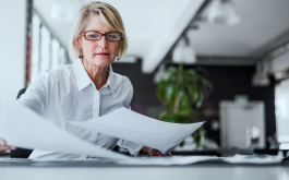 focused woman looking at papers on a table