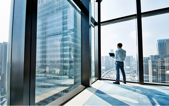 man in suit standing by a window